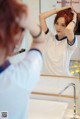 A woman brushing her hair in front of a mirror.