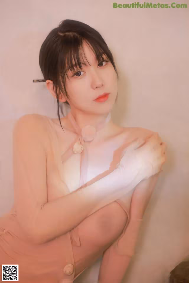 A woman in a pink dress and white gloves posing for a picture.